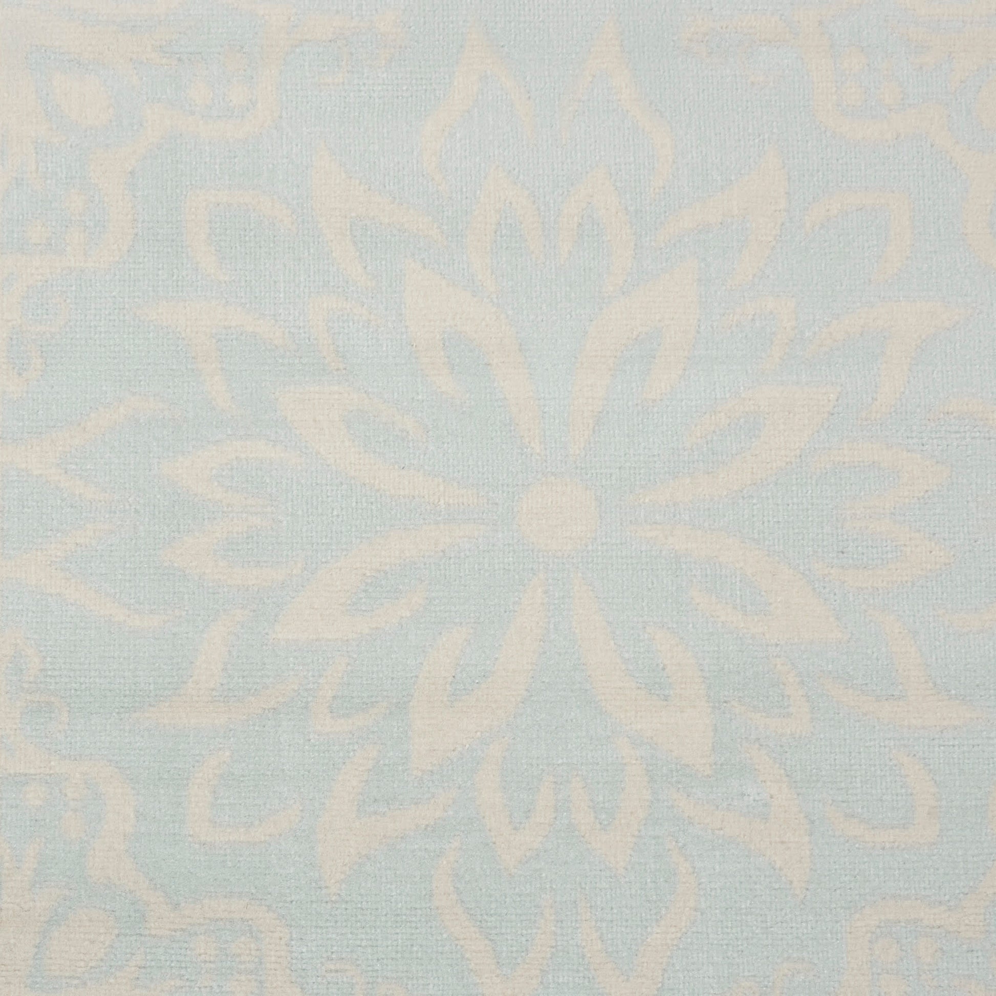 Pale blue damask rug with ivory floral medallion pattern.