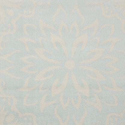 Pale blue damask rug with ivory floral medallion pattern.