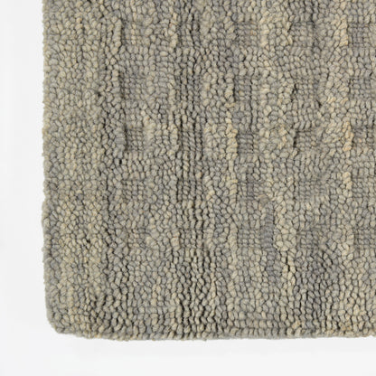 Grey-beige boucle rug with chunky loop pile and subtle abstract pattern; soft, textured floor covering.