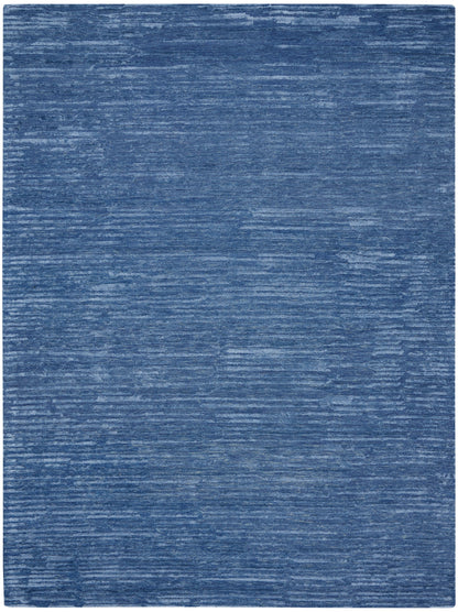 Blue distressed area rug with denim-like brushed texture and subtle lighter streaks.