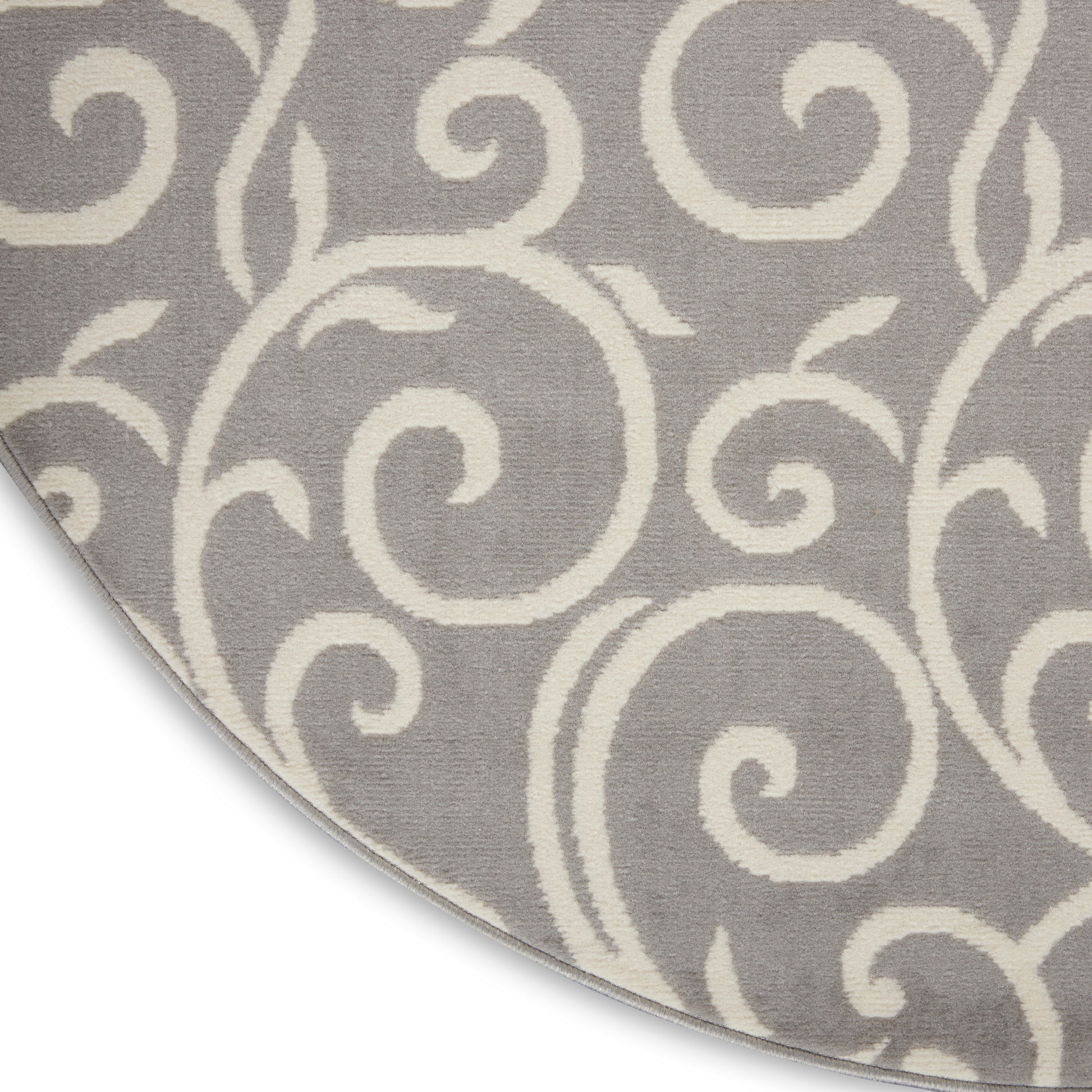 Round gray rug with white scrollwork pattern, soft textured pile for living room decor