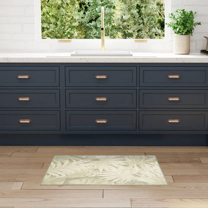 Navy blue kitchen cabinets with copper handles, white quartz countertop, gold faucet, pale green leafy rug on wood floor.
