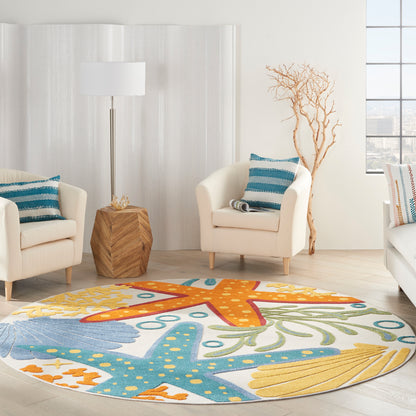 Bright living room with round rug featuring orange and turquoise starfish motif; cream armchairs, teal pillows, wood side table, floor lamp.