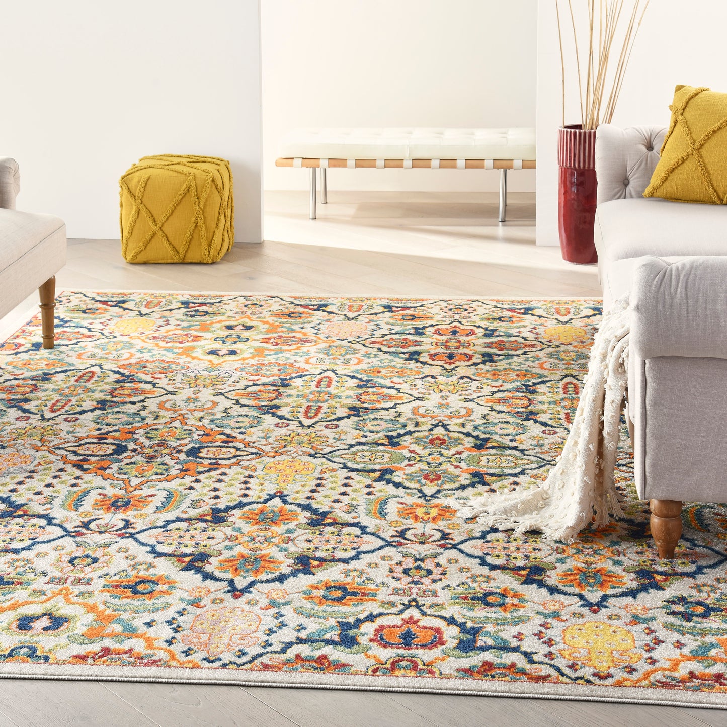 Colorful woven oriental-style area rug with blue, orange and yellow floral motifs in a bright living room.