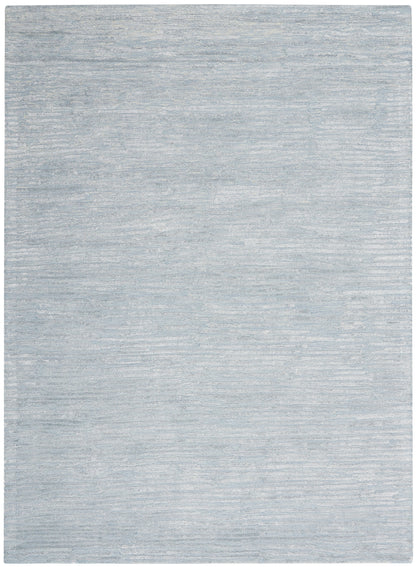 Light blue-gray rug with subtle tonal texture; rectangular decorative rug.