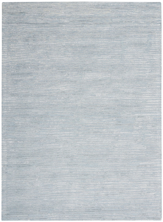 Light blue-gray rug with subtle tonal texture; rectangular decorative rug.