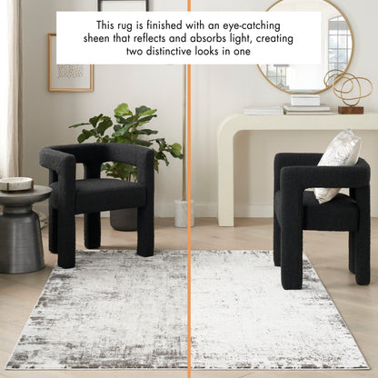 Two-tone area rug with dark-left and light-right sheen in a modern living room with black sculptural chairs.