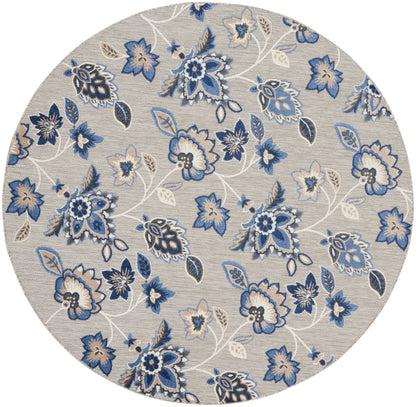 Round beige rug featuring blue floral pattern with white vines and leaves.