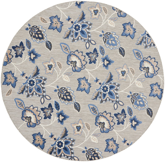 Round beige rug featuring blue floral pattern with white vines and leaves.