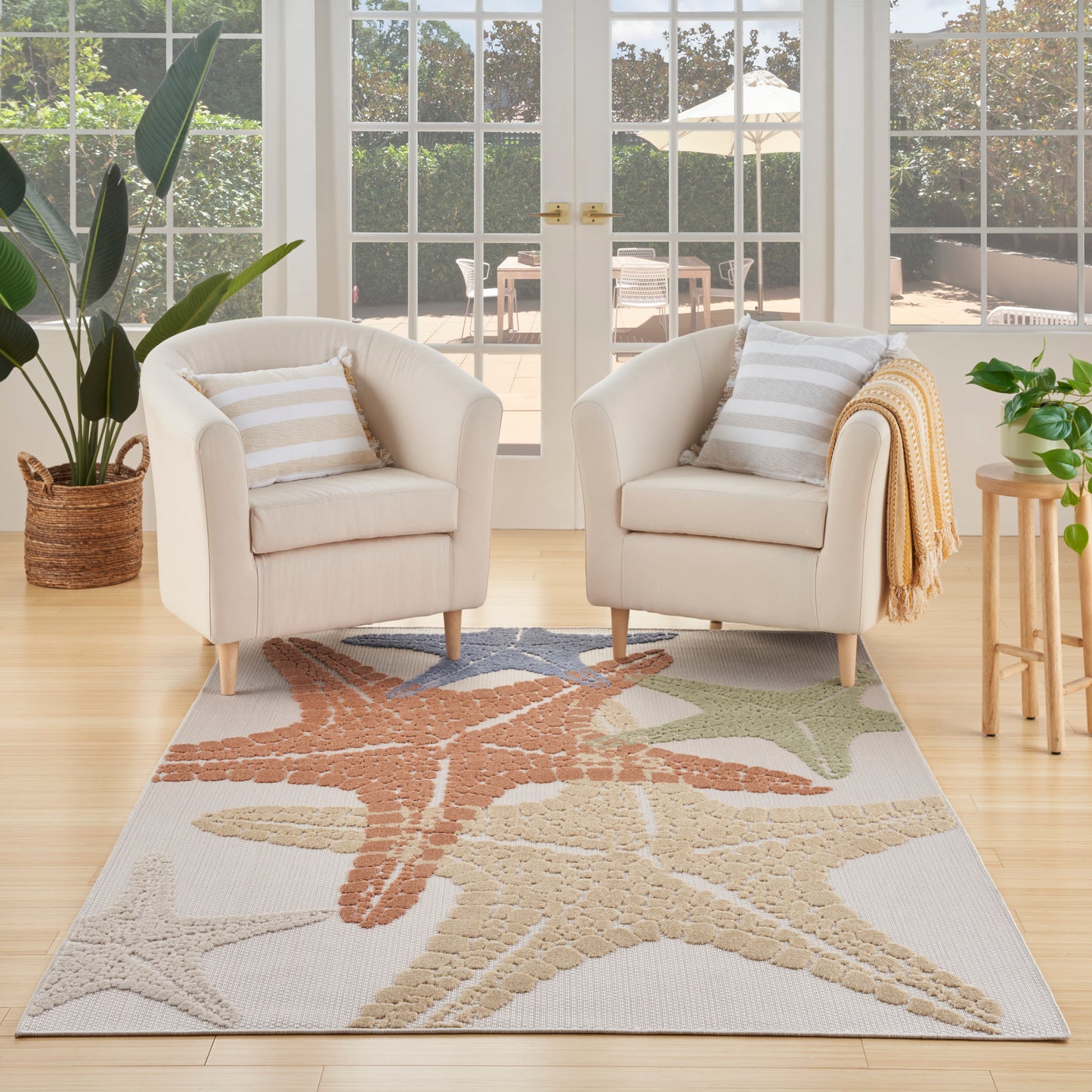 Outdoor rug with starfish pattern in beige, tan, coral and sage; 5' x 8'.