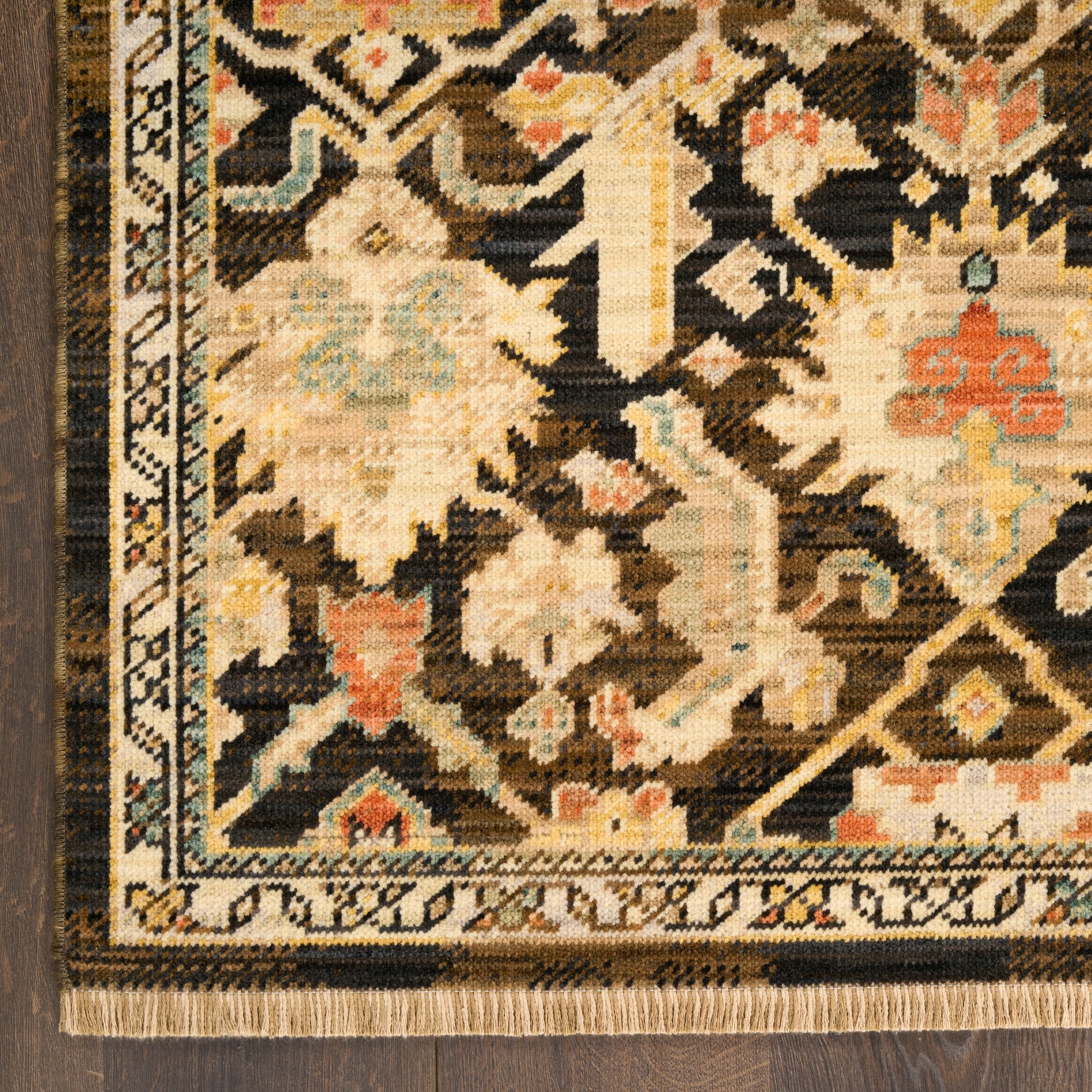 Close-up of an ornate Persian-style rug with beige, ivory and brown floral motifs, dark field, intricate border and fringe.