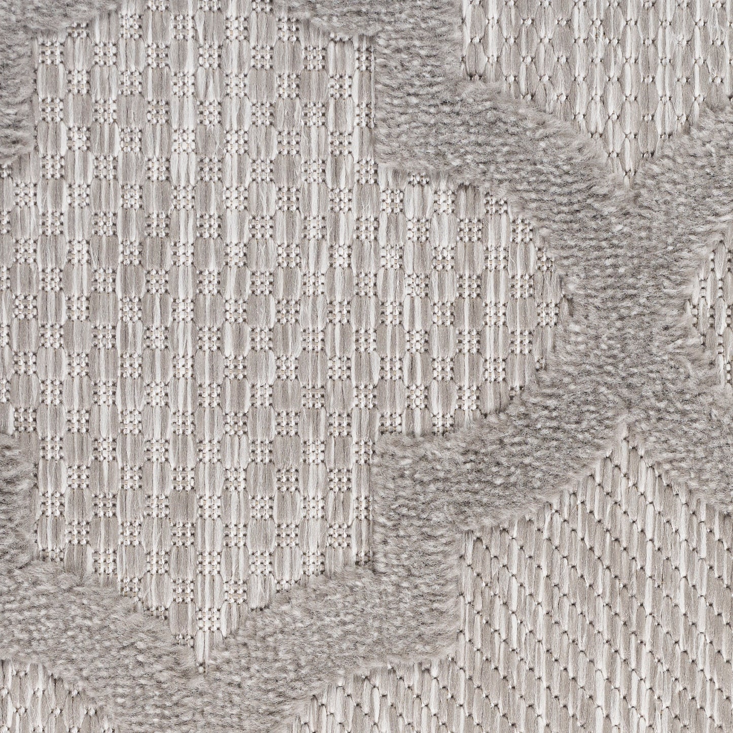 Light gray woven rug with a subtle geometric diamond pattern and soft, fluffy taupe border accents.