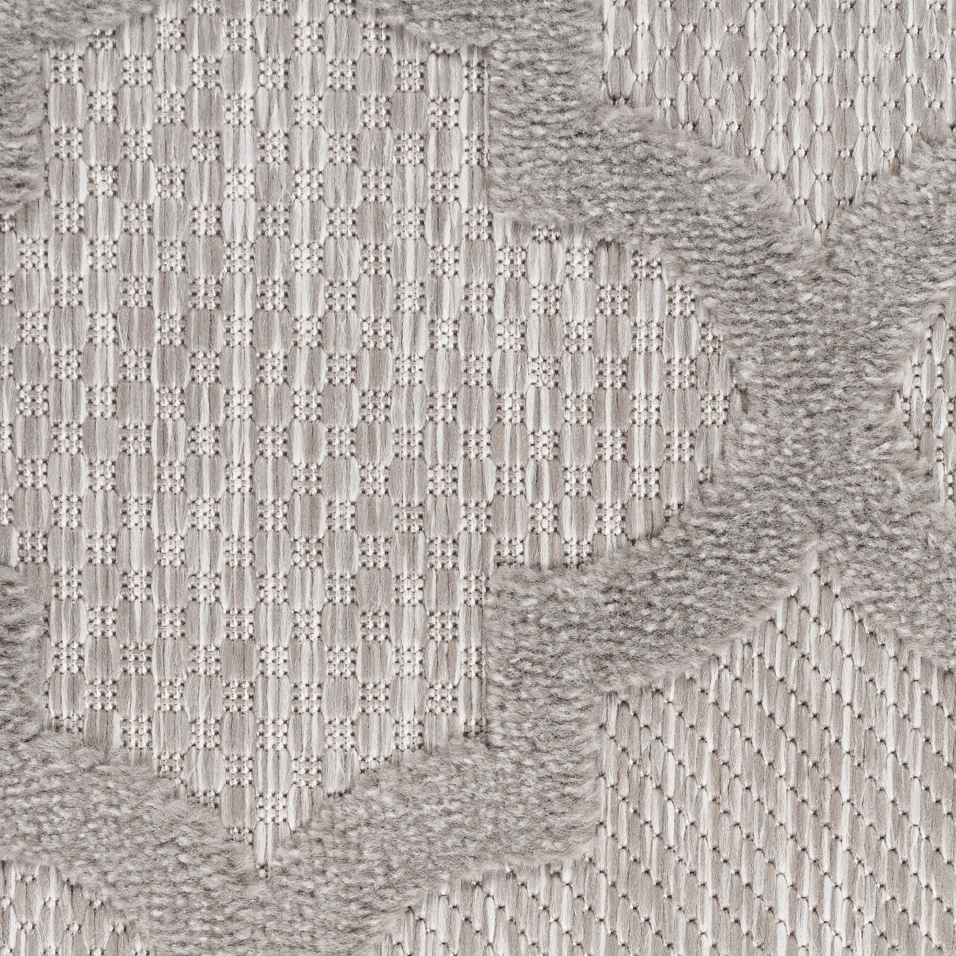 Light gray woven rug with a subtle geometric diamond pattern and soft, fluffy taupe border accents.