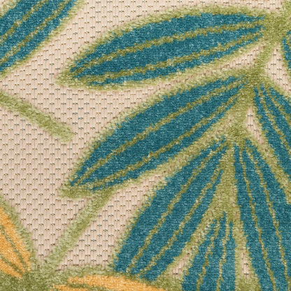 Close-up of a textured rug with teal blue and lime green leaf motifs on a beige woven background.