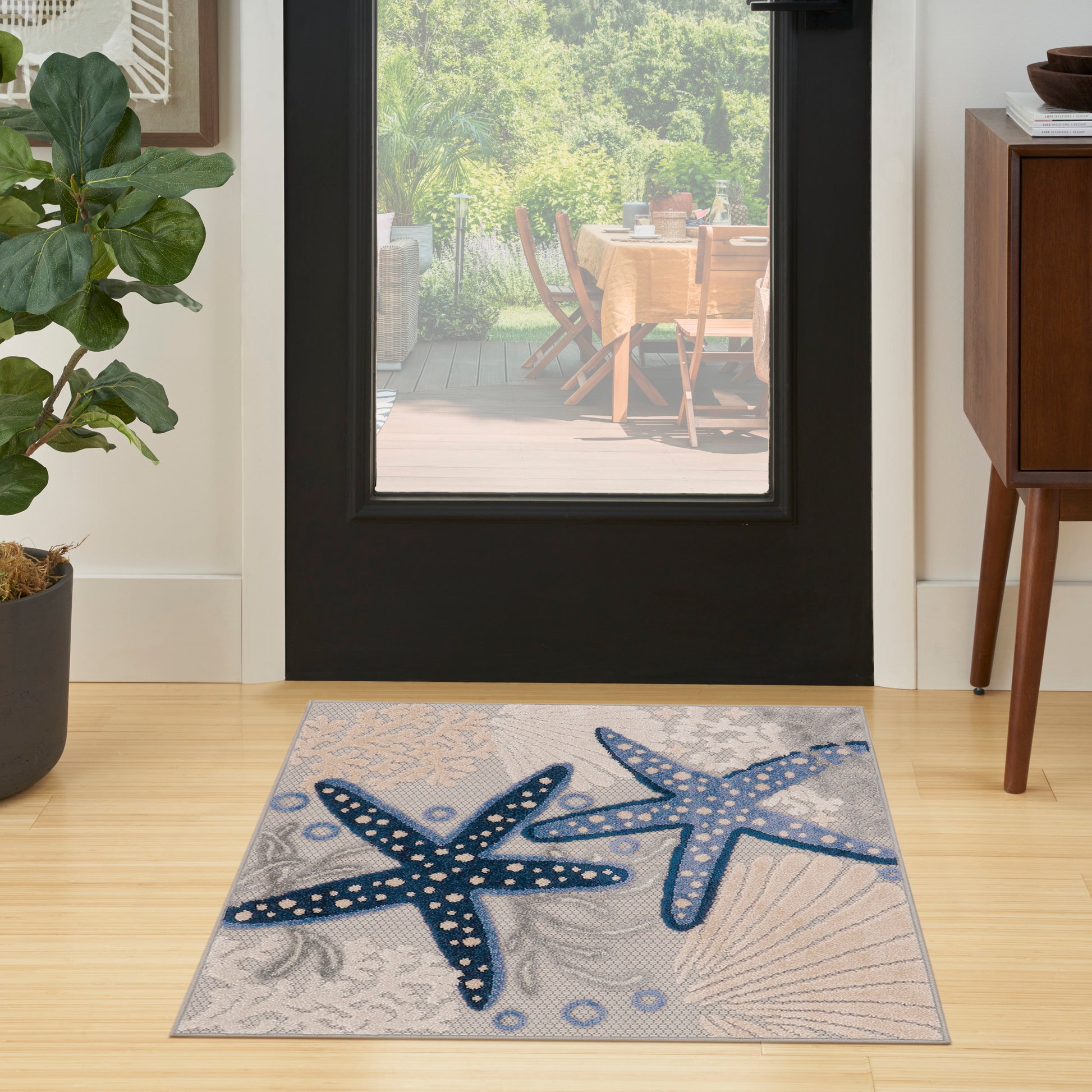 Coastal rug featuring two blue starfish on a gray background in a modern entryway.