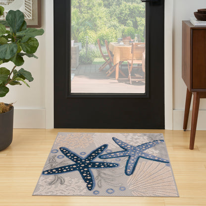Coastal rug featuring two blue starfish on a gray background in a modern entryway.