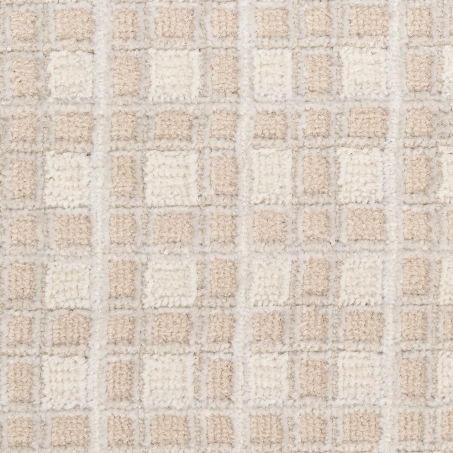 Beige and cream tufted rug close-up with a grid of soft square patches in neutral tones.