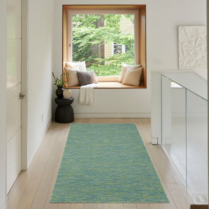 Turquoise diamond-pattern rug runner on light wood floor in a white hallway with window seat, cushions and glass railing.