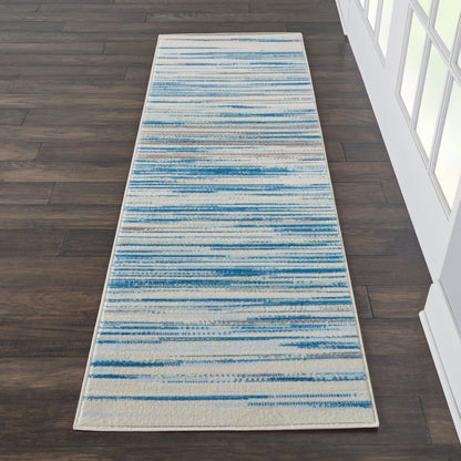 Long hallway runner rug with ivory background and blue abstract horizontal stripe pattern.