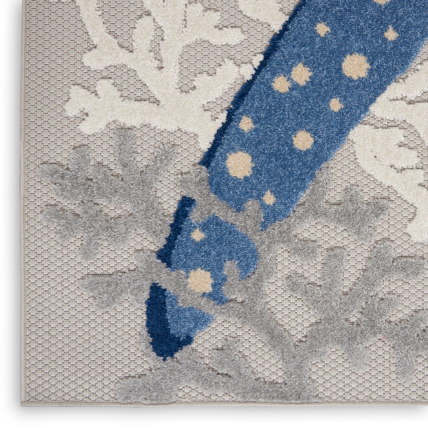 Blue polka-dot ribbon diagonally across cream damask fabric with frayed end.