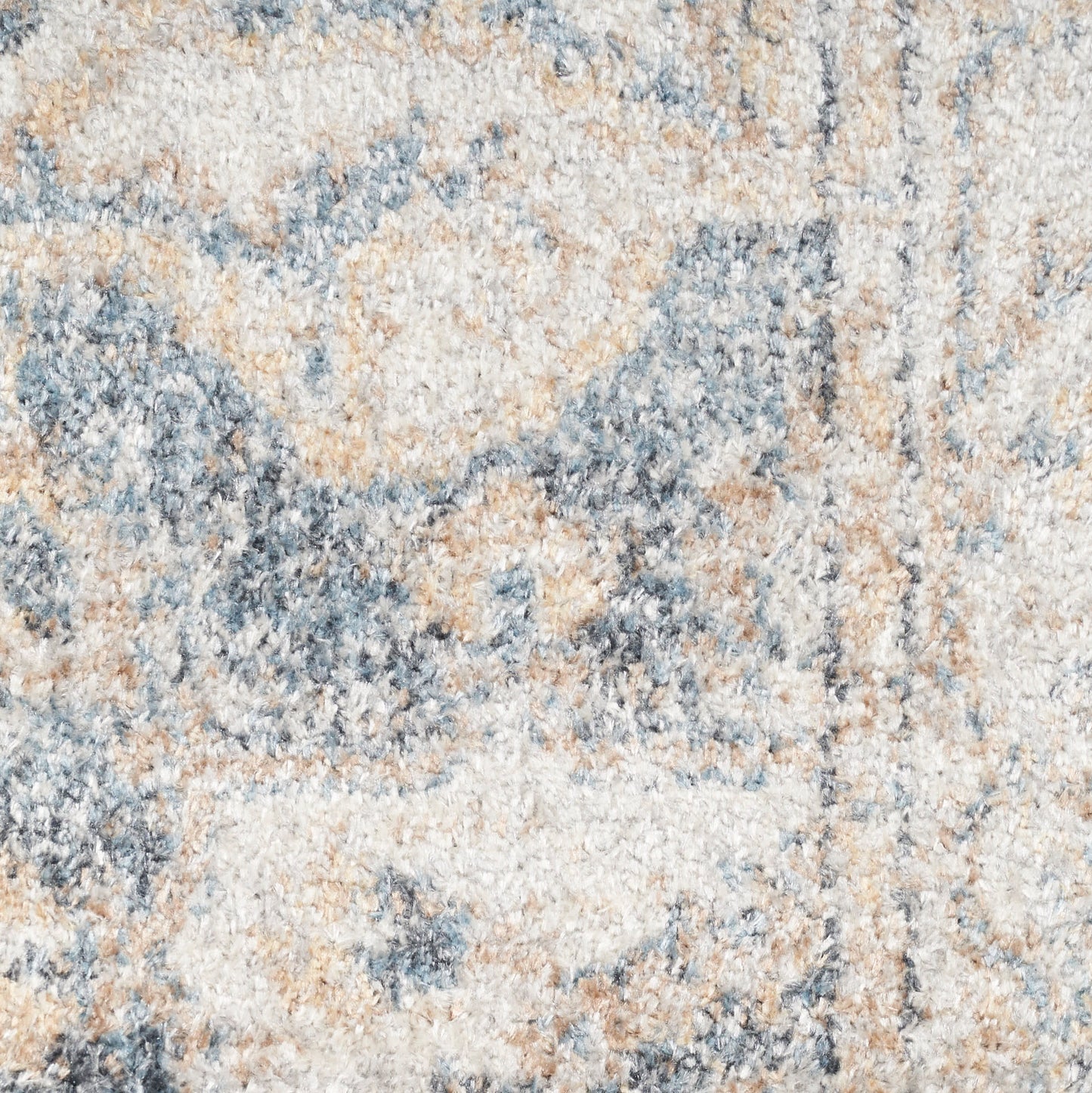 Soft high-pile area rug in cream, blue and tan with a distressed abstract pattern.