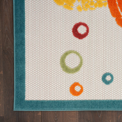 White rug with teal border and colorful ring motifs in red, green, orange, and blue on a wood floor.