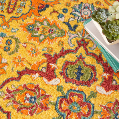 Vibrant yellow Oriental rug with red, blue and green floral motifs; stack of books beside a white-pot succulent.