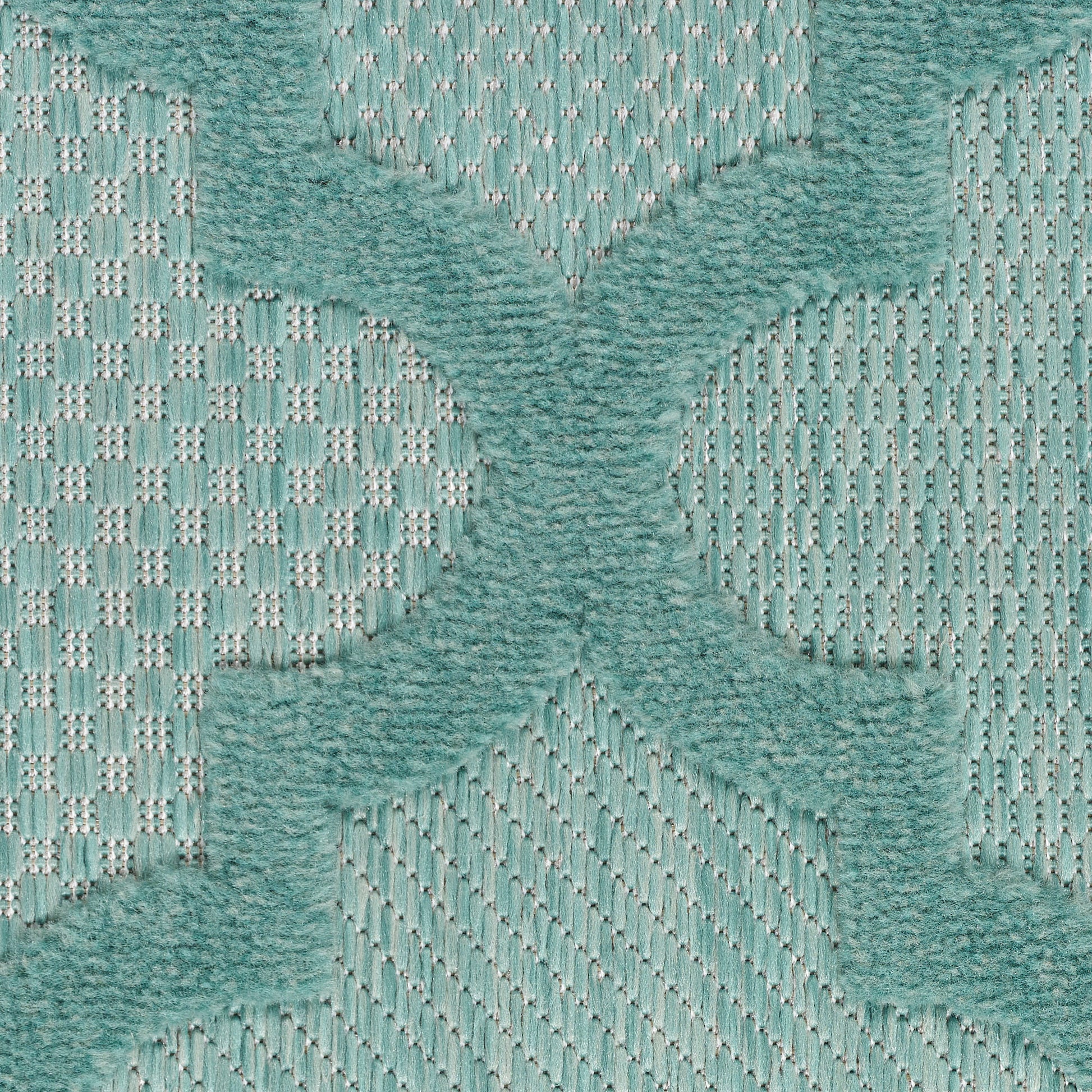 Teal tufted quatrefoil rug motif atop pale teal woven backdrop; plush, soft texture.