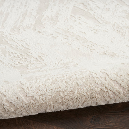 Cream textured shag rug with subtle pattern on dark wood floor.