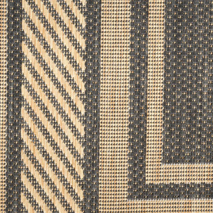 Beige and navy woven rug close-up with diagonal chevron, vertical stripes and square border motif.
