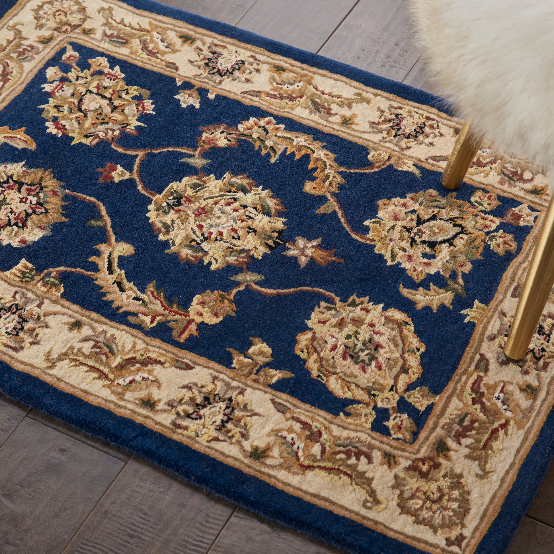 Blue Persian-style area rug with ivory floral border and cream medallions, decorative floor covering.