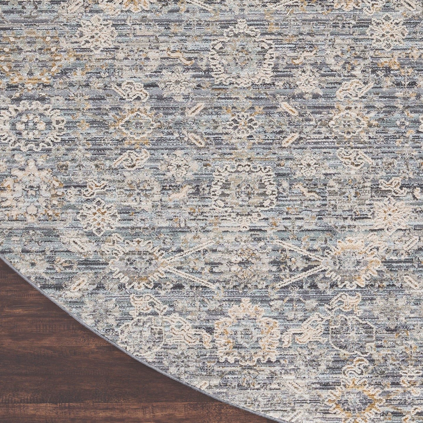 Blue-gray oriental vintage round rug, 8' diameter, with cream and pale-yellow floral medallions on a dark wood floor.