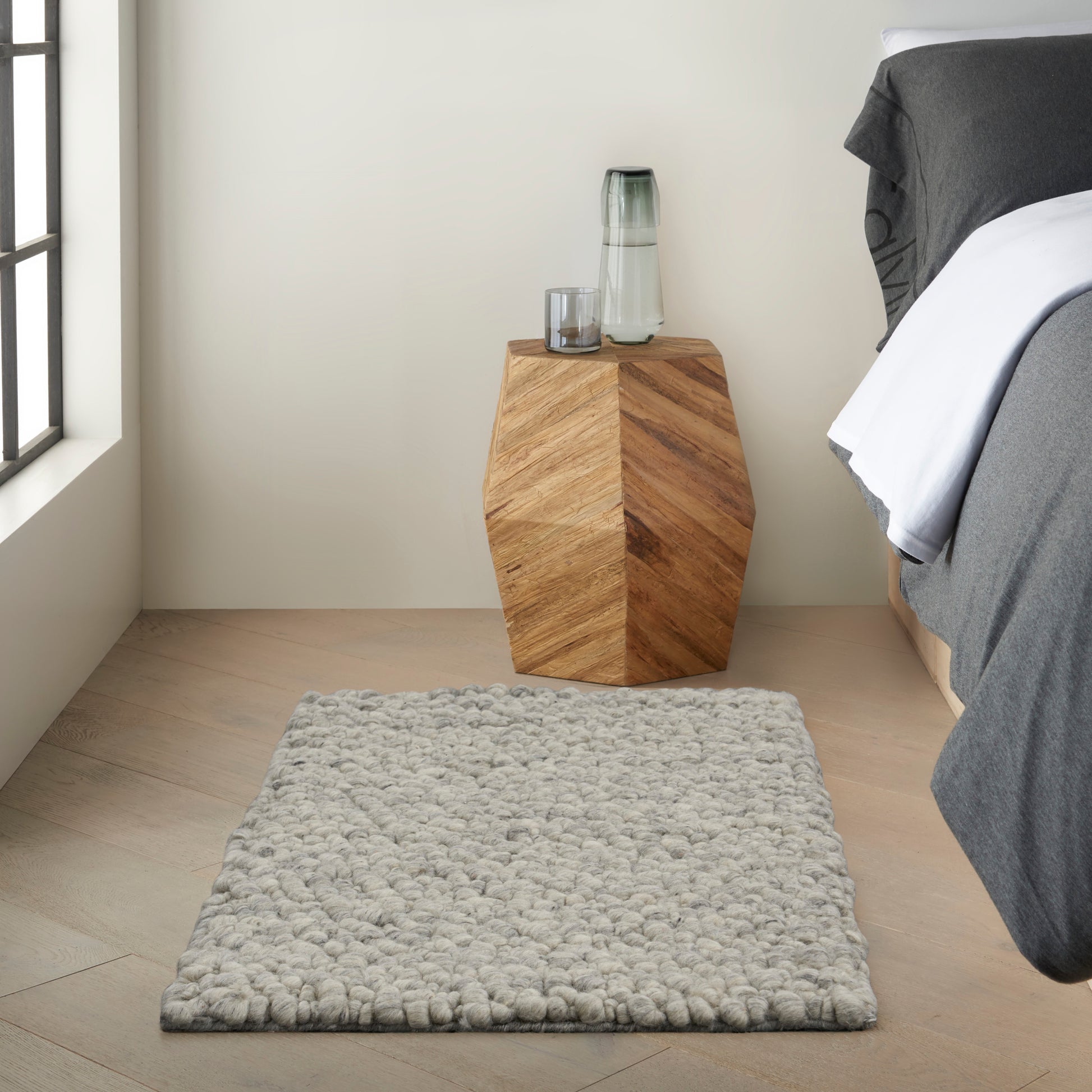 Contemporary geometric rug in gray tones on a light wood floor; 2' x 3' size.
