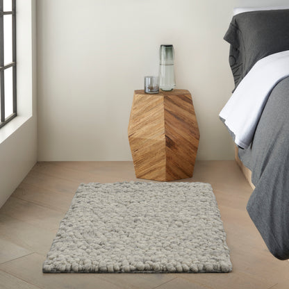 Contemporary geometric rug in gray tones on a light wood floor; 2' x 3' size.