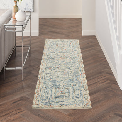 Blue and ivory geometric runner rug in hallway with a light border on dark wood floor.