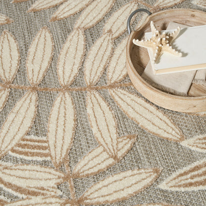 Beige leaf-patterned woven rug with textured leaves; round wooden tray holding a starfish and a book.