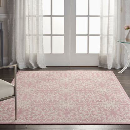 Rectangular pink damask-pattern area rug in a bright living room with French doors and sheer curtains.
