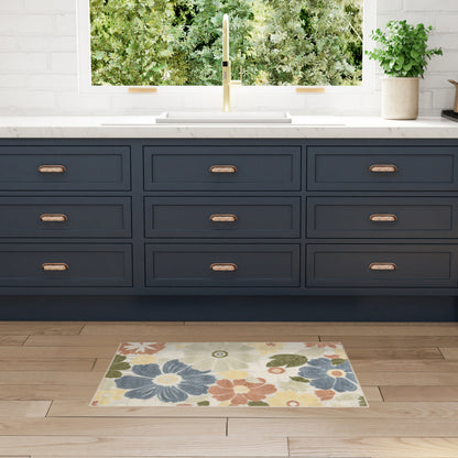 Navy blue kitchen cabinets & copper pulls, white marble countertop, gold faucet, window view; floral rug on wood floor.