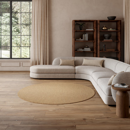 Neutral beige round jute rug, 8' diameter, on wood floors in a sunlit living room.
