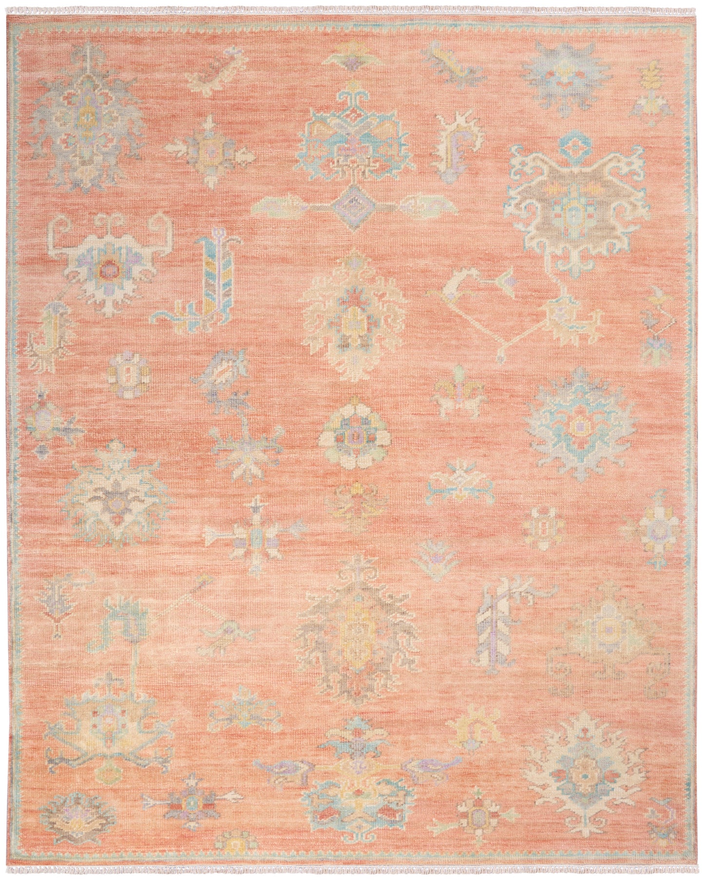 Peach-pink fringed oriental rug with pastel blue & ivory motifs; decorative border, soft woven texture for living areas.