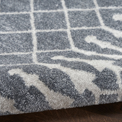 Close-up of a gray & white textured rug with a grid pattern & decorative border, soft loop pile.