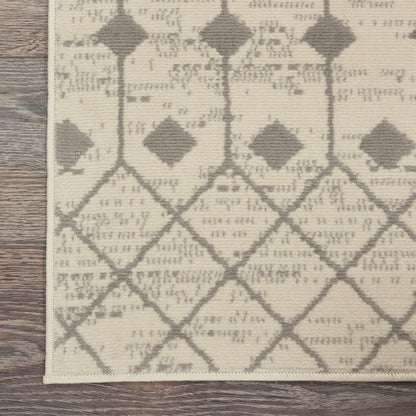 Beige woven rug with taupe diamond lattice pattern and slim border, shown on wood floor.