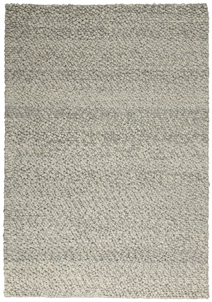 Rectangular light beige shag rug with dense, pebble-like tufted pile and gray undertones.