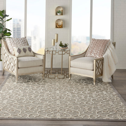 Neutral living room with two beige chairs, lattice wood frames, a gold side table, patterned pillows, and a gray geometric rug (8' x 11').