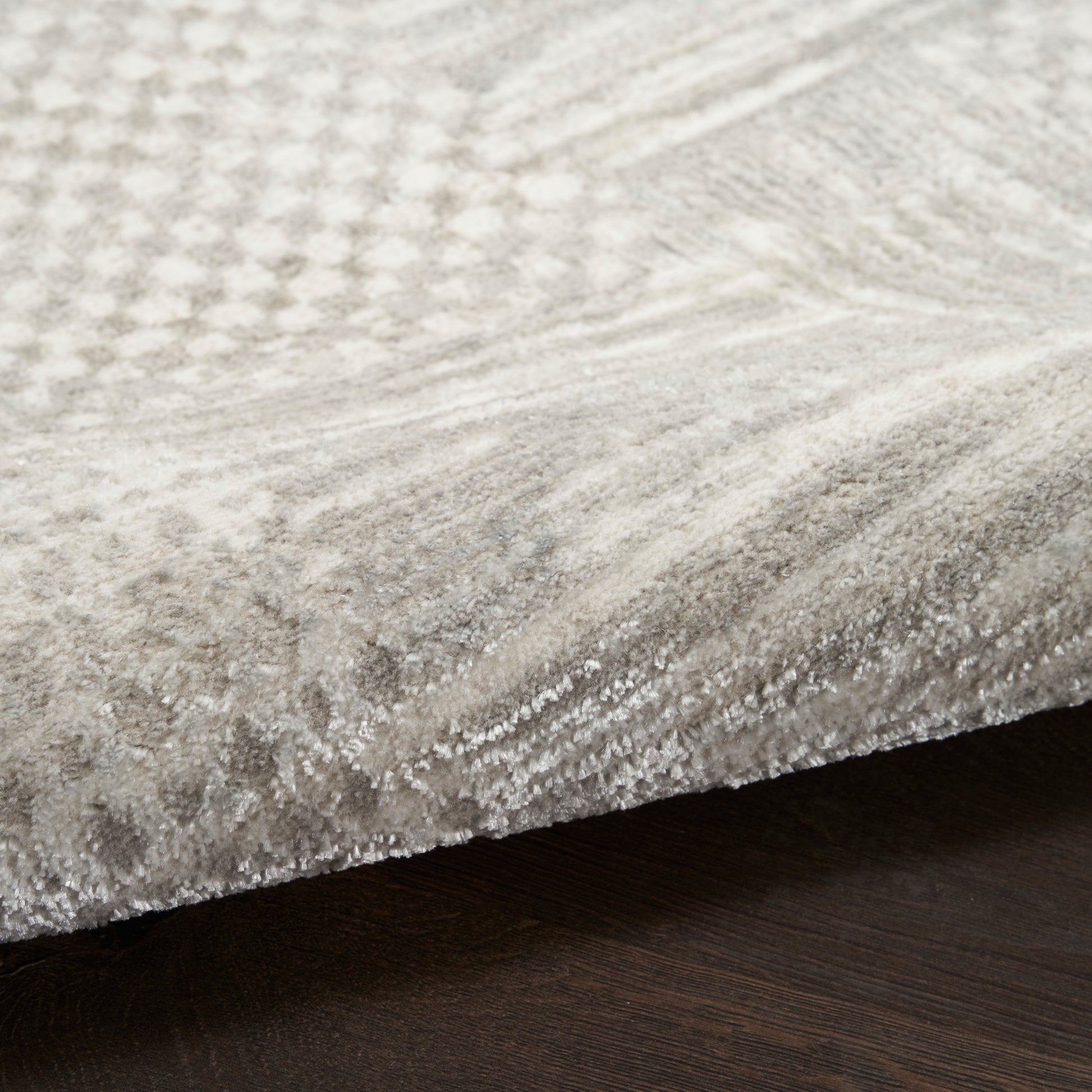 Soft light gray runner rug with subtle geometric pattern and dense plush pile on dark wood floor, 8' long.