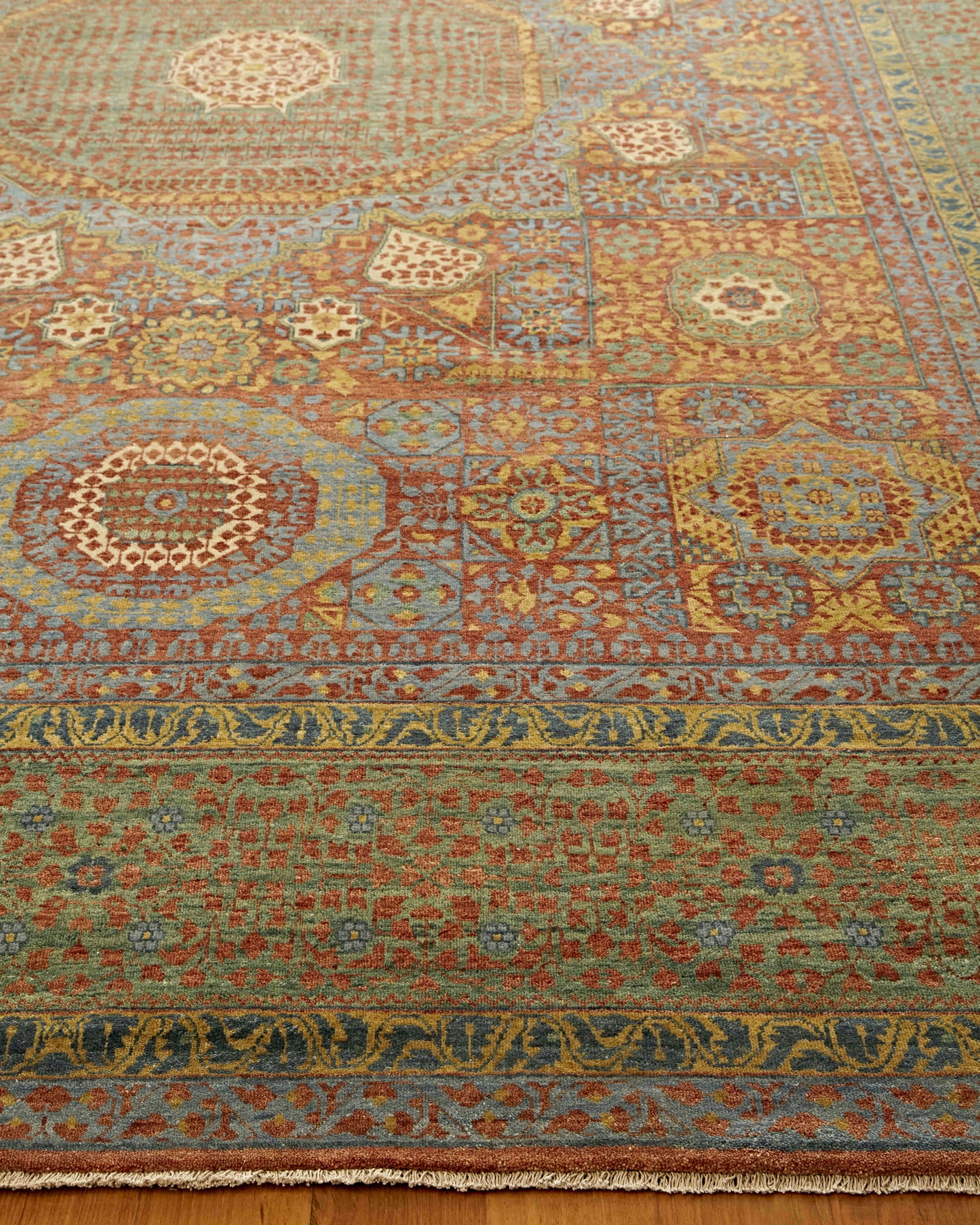 Rectangular wool rug with oriental medallion motifs, blue, red, gold and green tones; intricate borders and fringe.