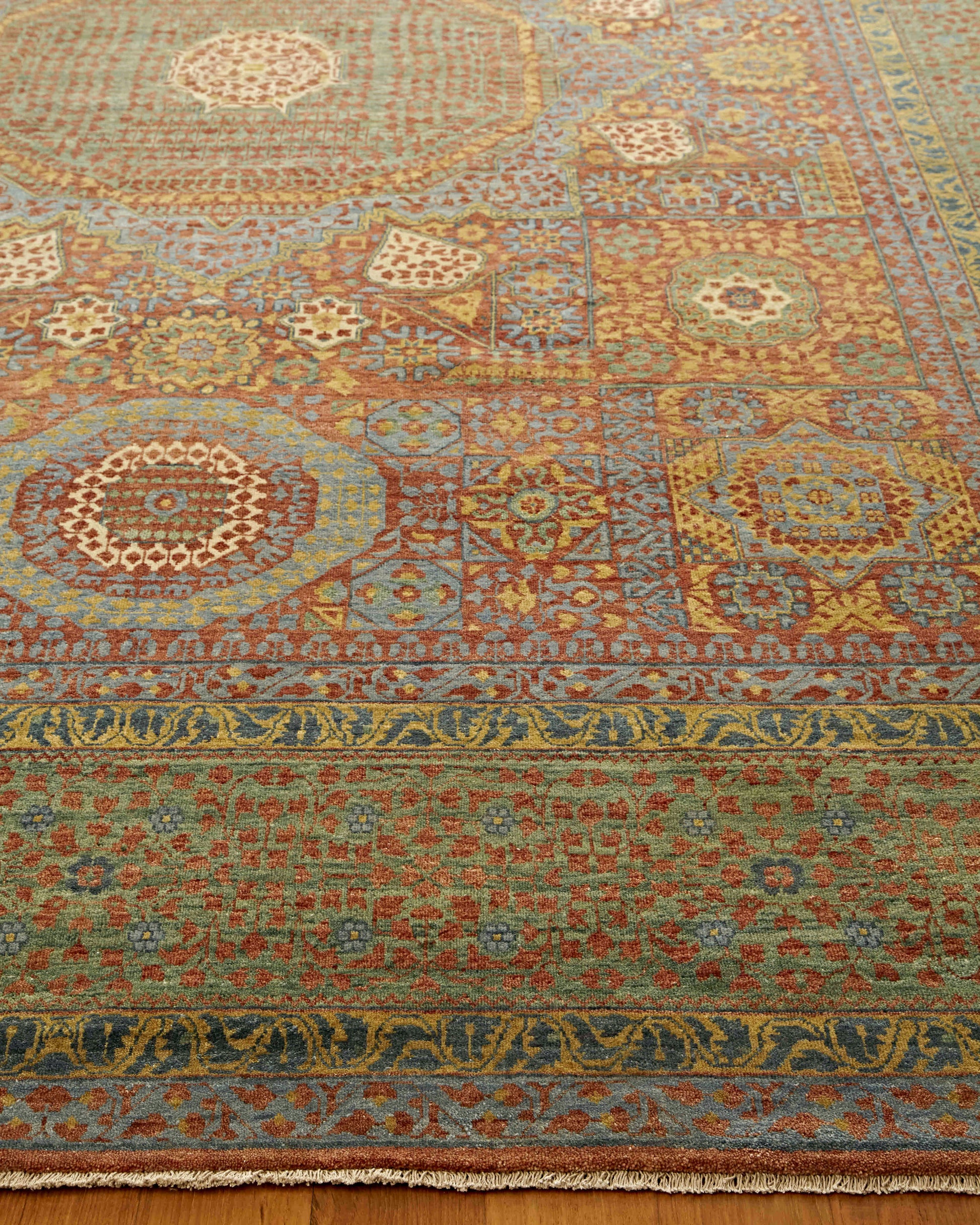 Rectangular wool rug with oriental medallion motifs, blue, red, gold and green tones; intricate borders and fringe.