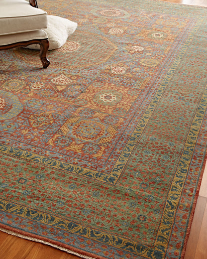 Large wool oriental rug with teal field, red and gold floral motifs, blue borders and fringed edge.