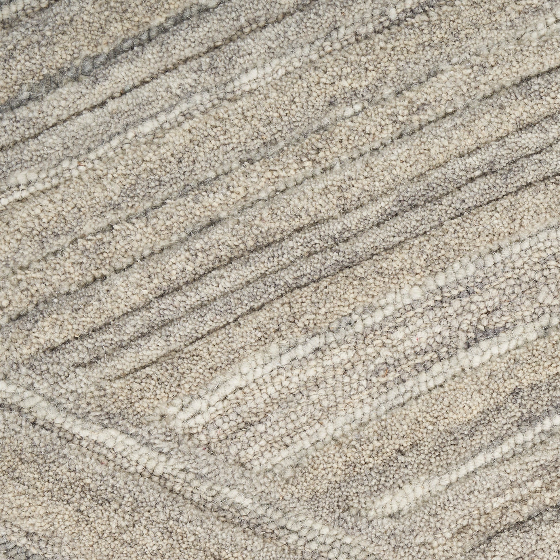 Close-up of a beige-gray boucle rug with soft, looped pile and diagonal striped pattern.