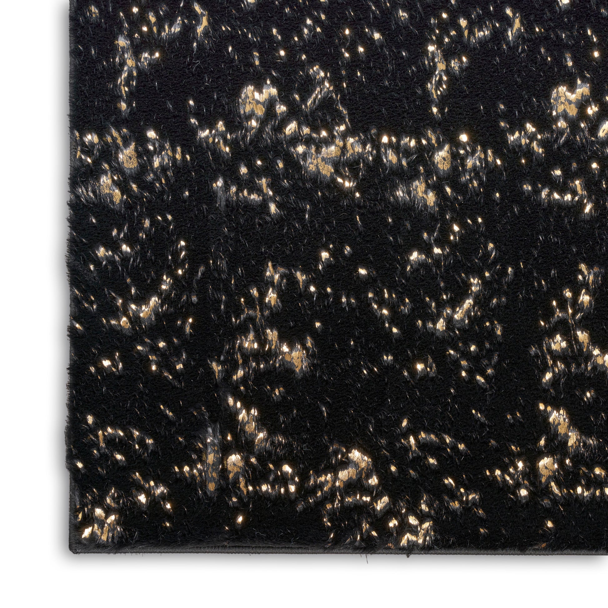 Close-up of black crushed velvet fabric with gold fleck accents, shimmering texture for evening wear or upholstery.